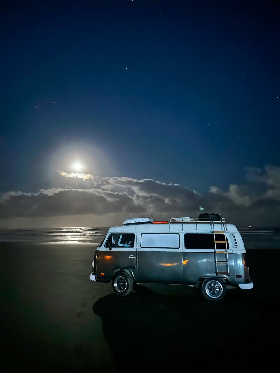 Kombi LocaHomes na praia sob a luz da lua